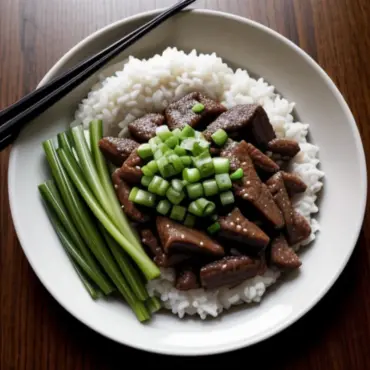 A steaming plate of stir-fried beef and onions
